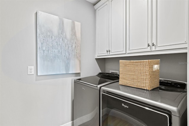 clothes washing area with cabinets and washer and clothes dryer