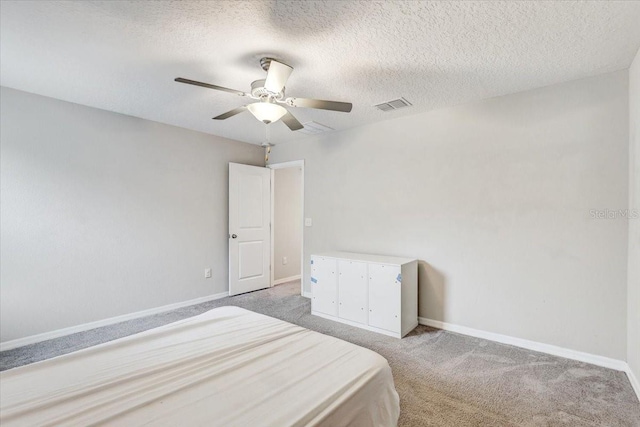 carpeted bedroom with ceiling fan and a textured ceiling