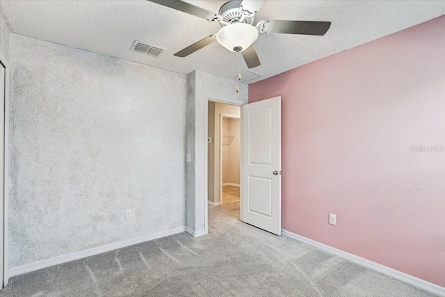 unfurnished room featuring light carpet, a textured ceiling, and ceiling fan