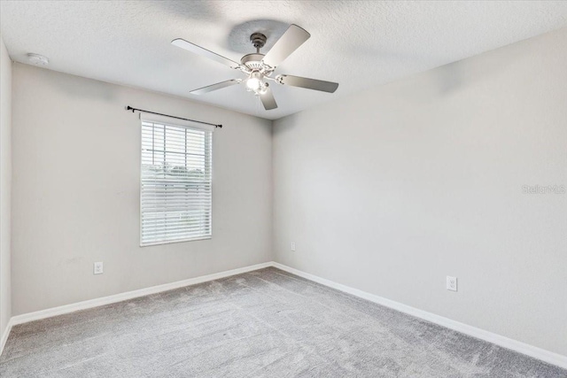 unfurnished room with a textured ceiling, ceiling fan, and carpet