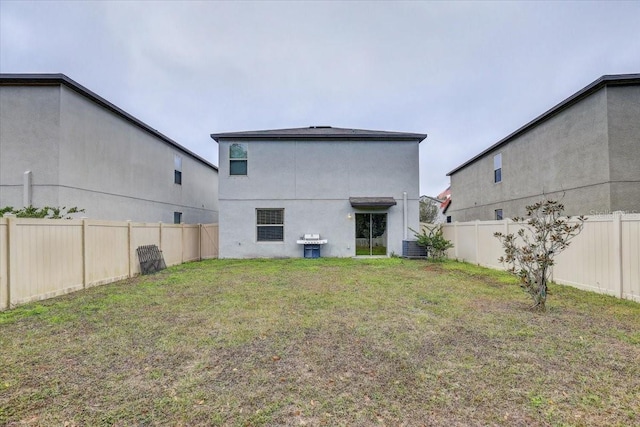 back of property featuring cooling unit and a lawn