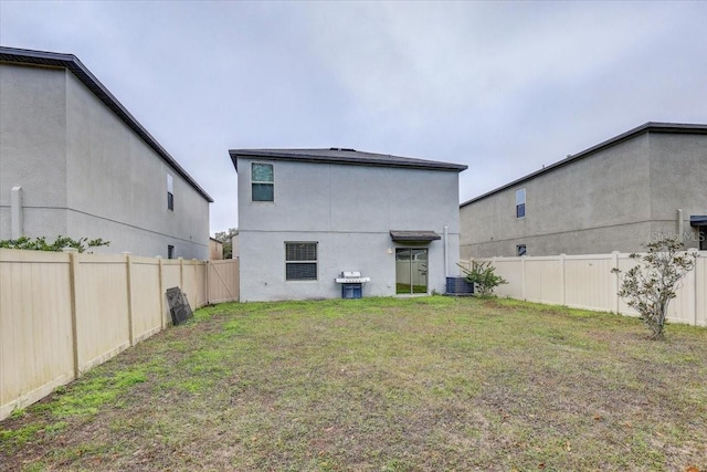 back of house featuring a yard and central AC unit