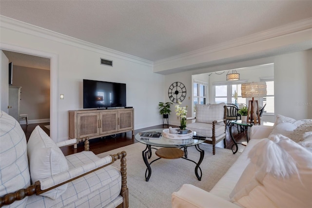 living room with hardwood / wood-style flooring, a textured ceiling, and ornamental molding