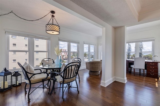 dining area with dark wood-type flooring, a textured ceiling, and crown molding