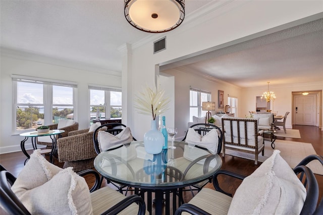 dining area featuring crown molding, an inviting chandelier, a textured ceiling, and dark wood-type flooring