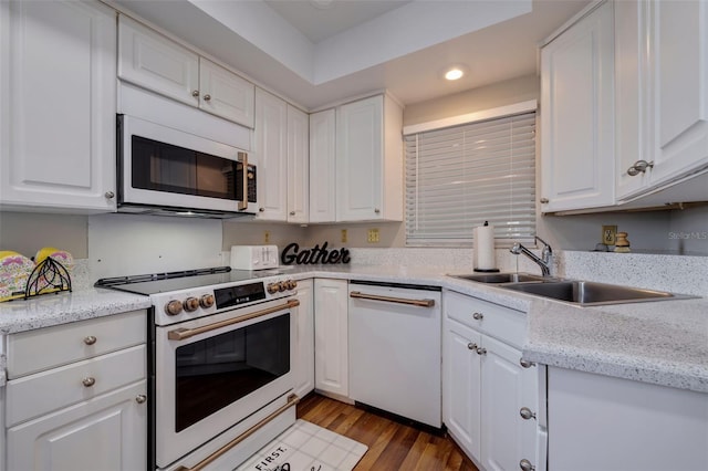 kitchen with white appliances, light wood-type flooring, and white cabinets