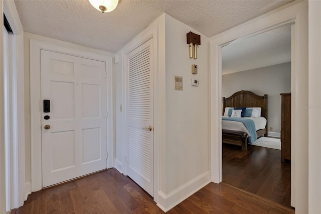 foyer with a textured ceiling and dark hardwood / wood-style flooring