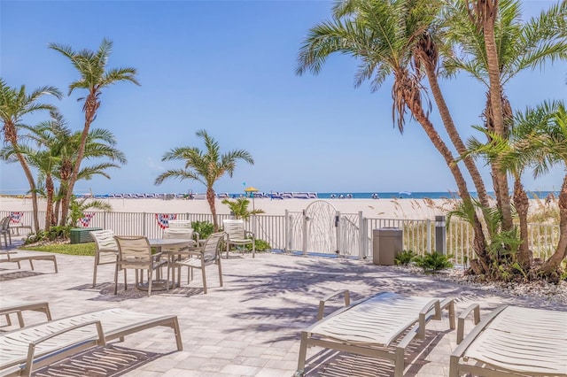 view of patio / terrace featuring a water view and a view of the beach