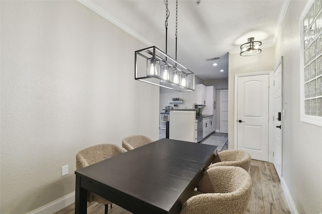 dining room with hardwood / wood-style floors and crown molding