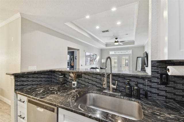 kitchen with sink, white cabinets, and a tray ceiling