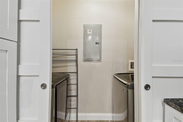 laundry area featuring washer and dryer, hardwood / wood-style flooring, and electric panel