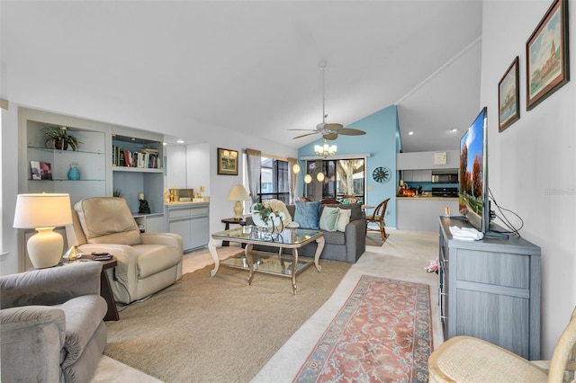 living room with ceiling fan, light colored carpet, built in shelves, and vaulted ceiling