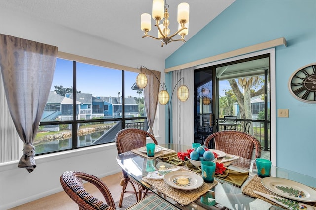 dining room with an inviting chandelier, a water view, vaulted ceiling, and carpet floors