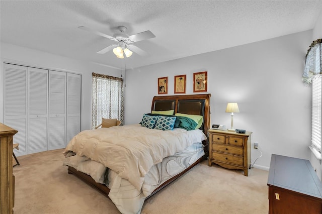 carpeted bedroom featuring ceiling fan, a textured ceiling, and a closet