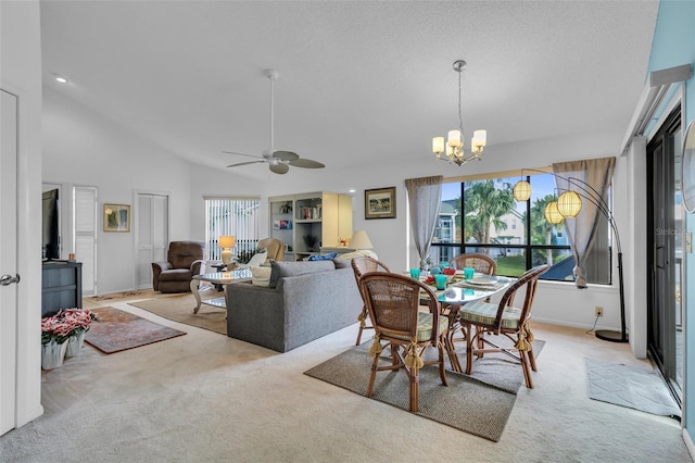 carpeted dining area featuring ceiling fan with notable chandelier and lofted ceiling