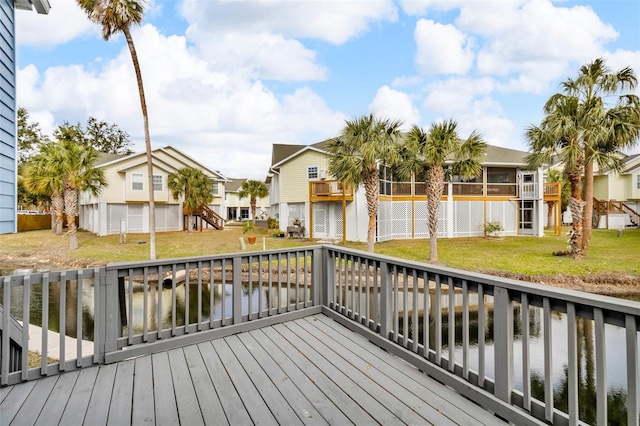 wooden terrace featuring a lawn and a water view