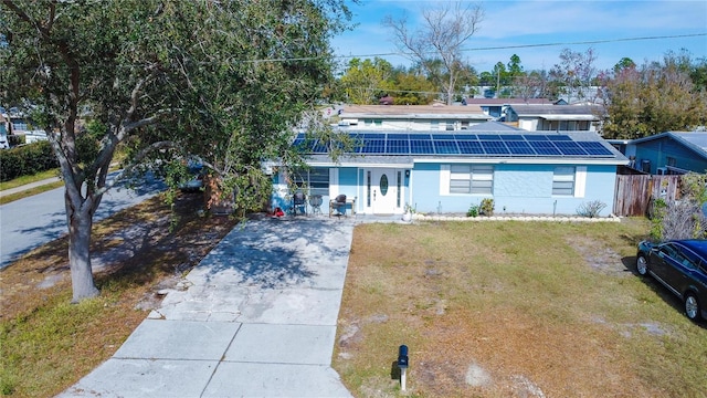 view of front property featuring a front lawn and solar panels