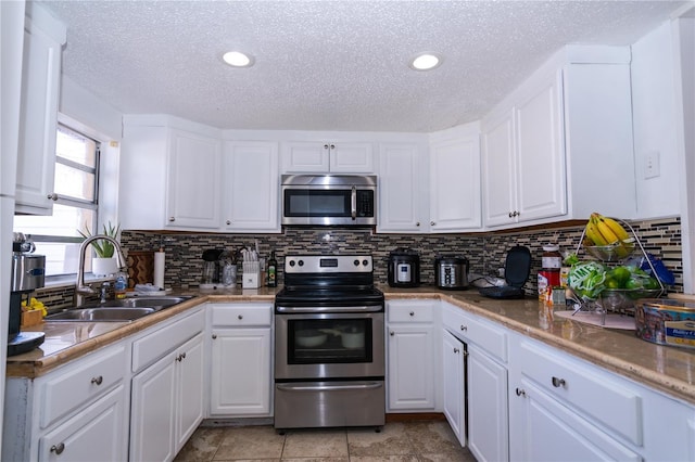 kitchen with sink, white cabinets, appliances with stainless steel finishes, and a textured ceiling