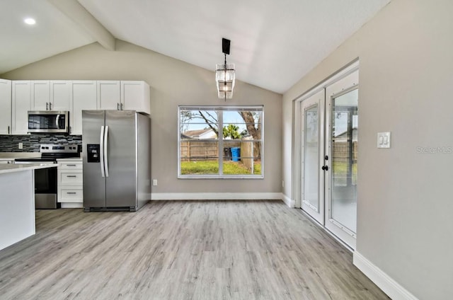 kitchen featuring white cabinets, decorative light fixtures, stainless steel appliances, vaulted ceiling with beams, and light hardwood / wood-style flooring