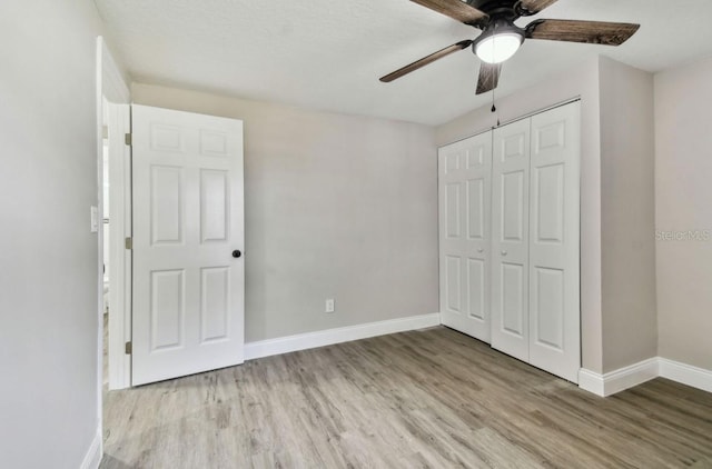 unfurnished bedroom with ceiling fan, light hardwood / wood-style floors, and a closet