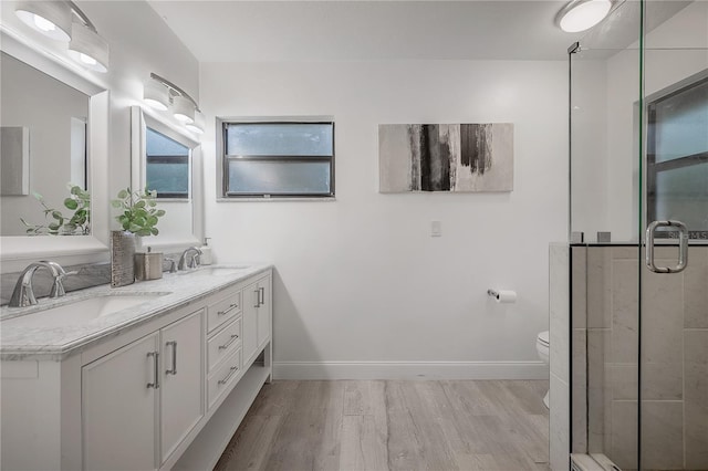 bathroom featuring a shower with shower door, wood-type flooring, toilet, and vanity