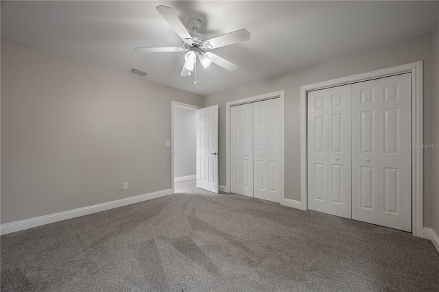 unfurnished bedroom featuring carpet floors, two closets, and ceiling fan