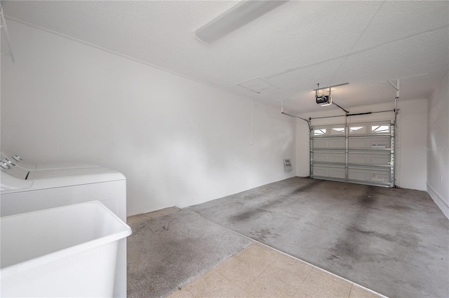 garage featuring separate washer and dryer, sink, and a garage door opener