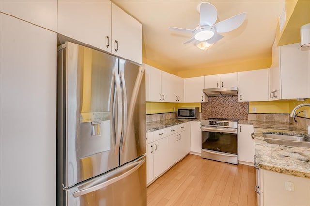 kitchen featuring sink, backsplash, white cabinets, light stone countertops, and stainless steel appliances