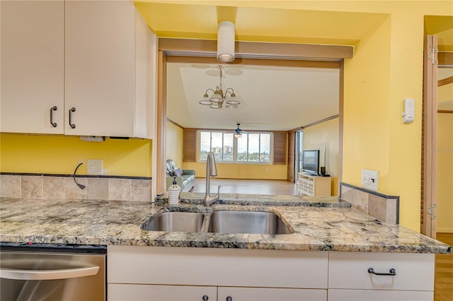 kitchen featuring sink, white cabinetry, and light stone countertops