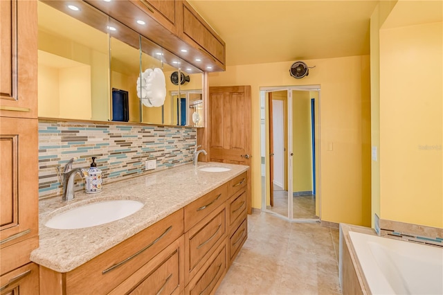 bathroom with vanity, a bathtub, and decorative backsplash