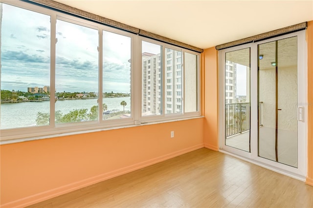 unfurnished sunroom with a healthy amount of sunlight and a water view