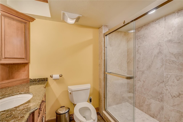 bathroom featuring vanity, toilet, and a shower with door