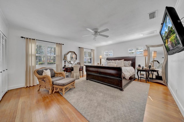 bedroom with ceiling fan, crown molding, and light wood-type flooring