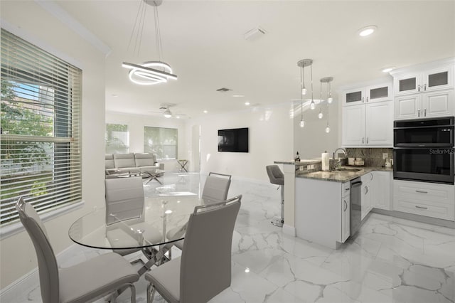 kitchen with pendant lighting, white cabinets, tasteful backsplash, dark stone countertops, and kitchen peninsula