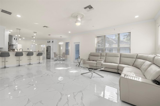 living room with ceiling fan and crown molding