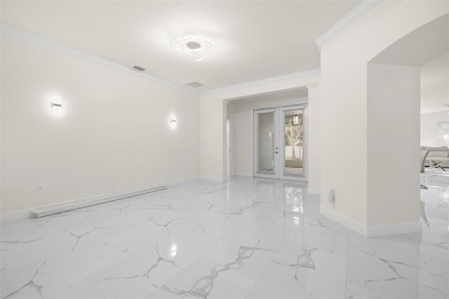 empty room with ornamental molding and a textured ceiling