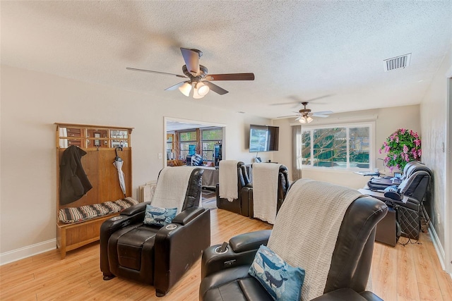 interior space with ceiling fan, a textured ceiling, and light hardwood / wood-style floors