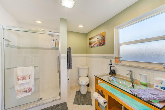 bathroom featuring tile walls, vanity, a shower with shower door, tile patterned floors, and toilet