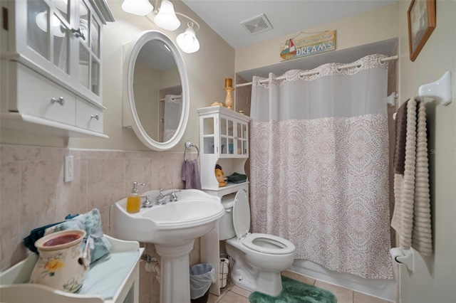 bathroom featuring tile walls, toilet, and tile patterned flooring