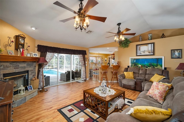 living room featuring lofted ceiling, light wood-type flooring, a fireplace, and ceiling fan