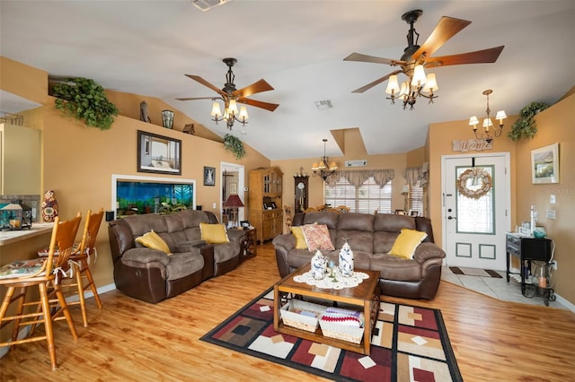 living room featuring vaulted ceiling, ceiling fan with notable chandelier, and light hardwood / wood-style flooring