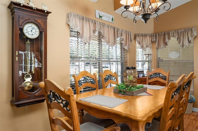 dining area featuring hardwood / wood-style flooring and an inviting chandelier