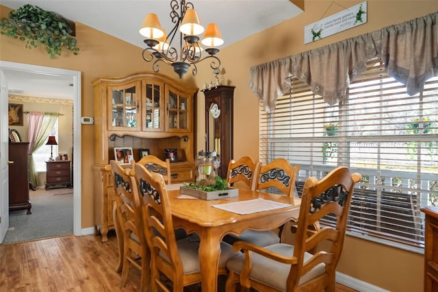 dining room with light wood-type flooring, plenty of natural light, and a chandelier