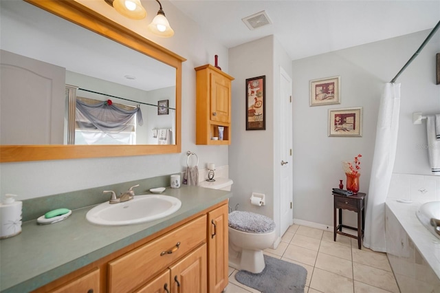 bathroom with tiled bath, vanity, tile patterned floors, and toilet