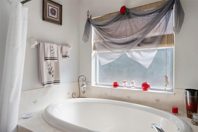 bathroom featuring a healthy amount of sunlight and a relaxing tiled tub