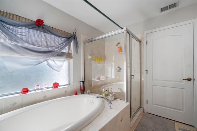 bathroom featuring plus walk in shower and tile patterned floors