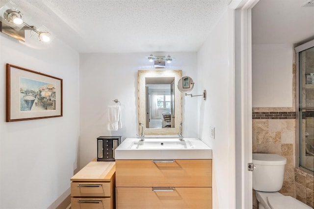 bathroom featuring vanity, toilet, tile walls, and a textured ceiling