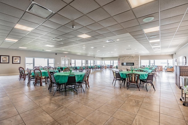 dining area featuring light tile patterned floors and a drop ceiling