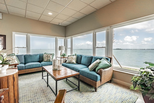 sunroom / solarium featuring a water view and a drop ceiling