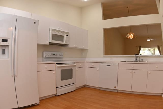 kitchen featuring white appliances, a sink, white cabinetry, light countertops, and light wood-type flooring